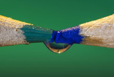 Yeşil ve mavi kalemle bir damla su yakın.