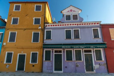 Burano adasının renkli evleri. İtalya 'nın Venedik Bölgesi' nde, Venedik Eyaleti 'nde balıkçı tekneleri ve taş köprüsü olan dar su kanalının fondamenta dolgusu üzerinde çok renkli binalar. Burano kartpostalı