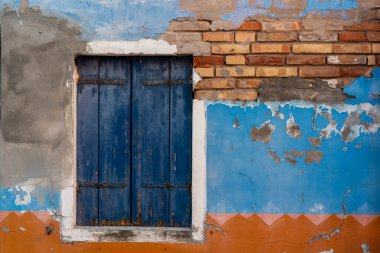 Burano adasının renkli evleri. İtalya 'nın Venedik Bölgesi' nde, Venedik Eyaleti 'nde balıkçı tekneleri ve taş köprüsü olan dar su kanalının fondamenta dolgusu üzerinde çok renkli binalar. Burano kartpostalı