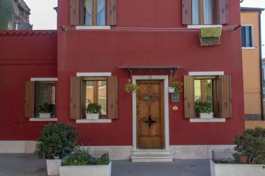 Burano adasının renkli evleri. İtalya 'nın Venedik Bölgesi' nde, Venedik Eyaleti 'nde balıkçı tekneleri ve taş köprüsü olan dar su kanalının fondamenta dolgusu üzerinde çok renkli binalar. Burano kartpostalı