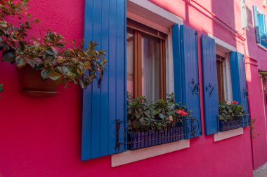 Burano adasının renkli evleri. İtalya 'nın Venedik Bölgesi' nde, Venedik Eyaleti 'nde balıkçı tekneleri ve taş köprüsü olan dar su kanalının fondamenta dolgusu üzerinde çok renkli binalar. Burano kartpostalı