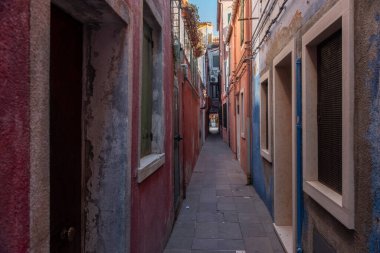 Burano adasının renkli evleri. İtalya 'nın Venedik Bölgesi' nde, Venedik Eyaleti 'nde balıkçı tekneleri ve taş köprüsü olan dar su kanalının fondamenta dolgusu üzerinde çok renkli binalar. Burano kartpostalı