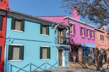 Burano adasının renkli evleri. İtalya 'nın Venedik Bölgesi' nde, Venedik Eyaleti 'nde balıkçı tekneleri ve taş köprüsü olan dar su kanalının fondamenta dolgusu üzerinde çok renkli binalar. Burano kartpostalı