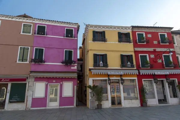 Burano adasının renkli evleri. İtalya 'nın Venedik Bölgesi' nde, Venedik Eyaleti 'nde balıkçı tekneleri ve taş köprüsü olan dar su kanalının fondamenta dolgusu üzerinde çok renkli binalar. Burano kartpostalı