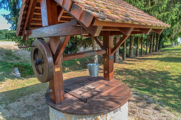 Rustic stone well with bucket and drinking water, Radenci, Slovenia