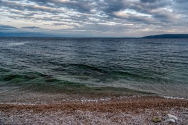 Moscenicka Draga, Hırvatistan. Akdeniz kıyısında arkada küçük bir kasaba yer almaktadır..
