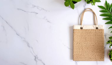 Bej örülmüş çanta mermer üzerinde doğa bitkileri kopya alanı ile arka plan