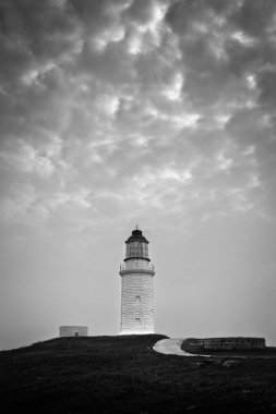 Dongju Adası 'ndaki Dongju Deniz Feneri. Siyah-beyaz dramatik gökyüzü.