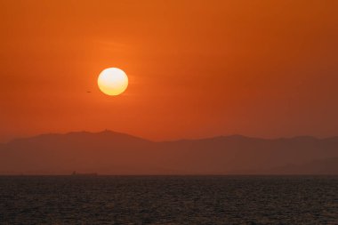 Uçak gün batımında Çin üzerinde uçuyor.