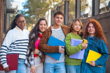  Sınıfta oturup notları inceleyen gülümseyen çok ırklı öğrenciler. Üniversite Yaşam Konsepti