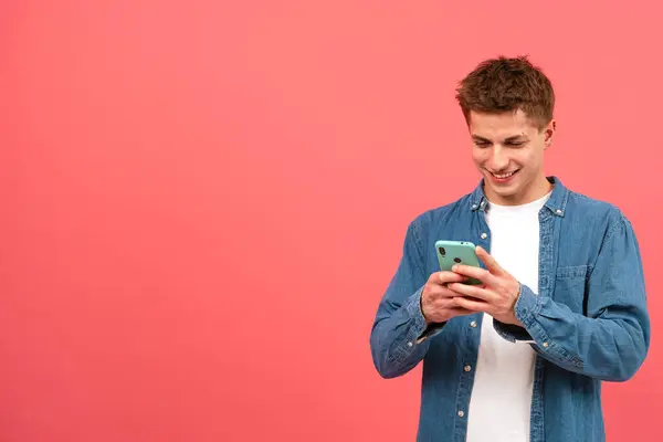 Portrait Happy Man Looking Mobile Phone Smiling Texting Pink Background — Stock Photo, Image