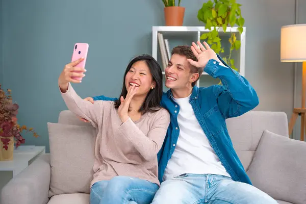 Young smiling multiracial friends taking a selfie in living room. Concepts of youth, peoples lifestyle, diversity, urban life