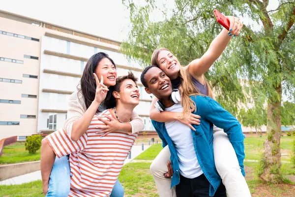 Junge Studenten Huckepack Ihre Kommilitonen Auf Dem Campus Aufgeregte Freunde — Stockfoto