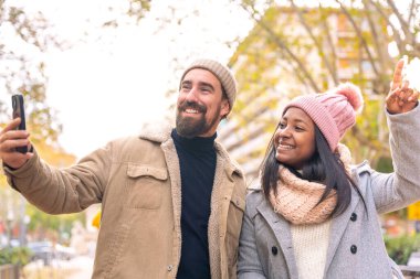 İyi alışveriş arkadaşları akıllı telefondan video görüşmesi yapıyor. Hipermarkette eğleniyorlar. Eşler, modern bir alışveriş merkezinde hafta sonunun tadını çıkarırlar. Kara Cuma