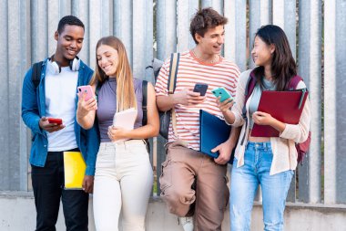 Genç öğrenciler akıllı telefondan komik bir şey izleyip gülüyorlar. Kampüs konsepti: Üniversite hayatı