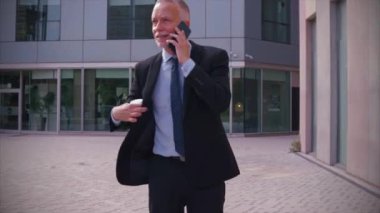 Sonuçlardan memnun olan işadamı caddede ofis binasının önünde yürüyor, olgun bir patron telefonla konuşuyor, mesajlar yazıyor..