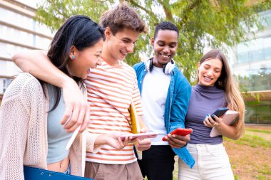 Akıllı telefonlarına bakan bir grup arkadaş kampüste interneti cep telefonuyla tarıyor.