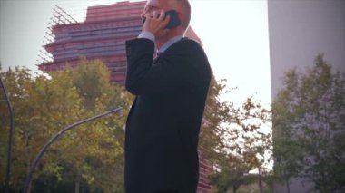 Sonuçlardan memnun olan işadamı caddede ofis binasının önünde yürüyor, olgun bir patron telefonla konuşuyor, mesajlar yazıyor..