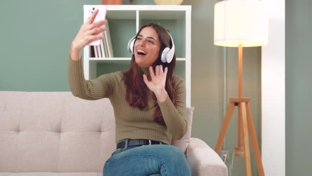 Vídeo Una Joven Feliz Usando Auriculares Hablando Con Amiga Teléfono — Vídeos de Stock