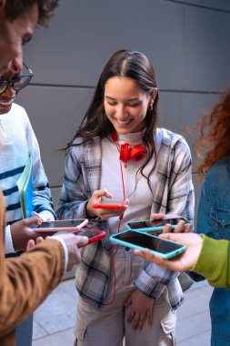 Akıllı telefonlarına bakan bir grup arkadaş kampüste interneti cep telefonuyla tarıyor.