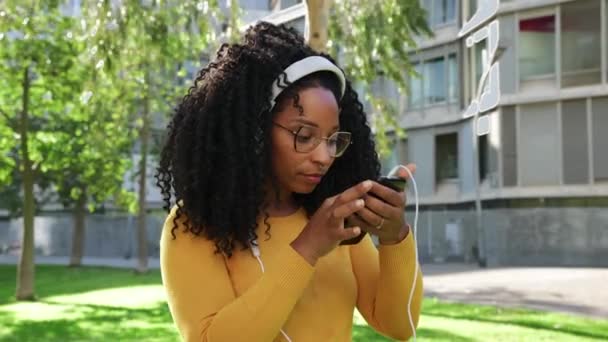 Sosyal Medya Uygulaması Kullanarak Gülümseyen Güzel Siyahi Bir Kadın Dışarıdaki — Stok video