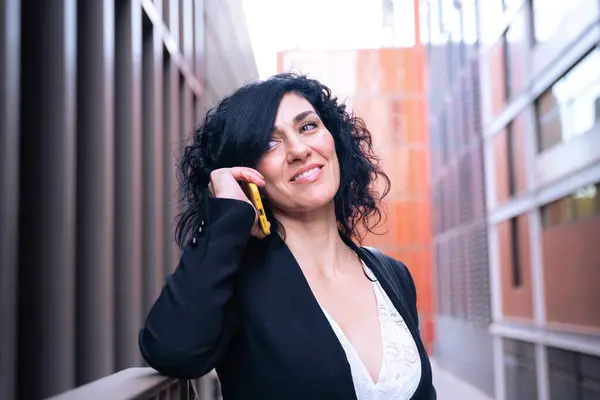  Güzel orta yaşlı beyaz kadın dışarıda cep telefonuyla konuşuyor..