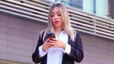 Güzel, ciddi ve sinirli kadın konuşmak için akıllı telefonunu kullanıyor. Bağlı konsept..