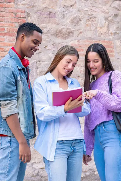 stock image Happy multiracial university student friends talking and laughing while reviewing syllabus notes on campus. Diverse American and European youth.Vertical