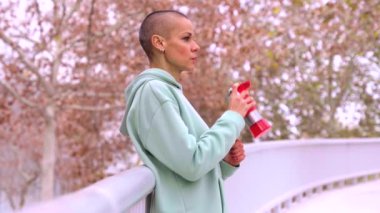 Sporcu kadın, egzersiz yaparken içme suyu molası verdi..