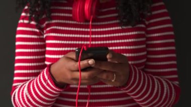 Akıllı telefon uygulamasında yazan güzel siyah kadın kolay ve güvenli elektronik ödemeler için cep telefonuyla mutlu online alışverişler..