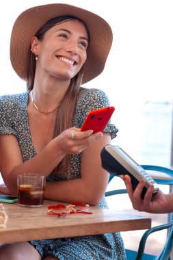 Lokantada içki içen arkadaşlar, cep telefonu uygulaması ile ücretsiz ödeme yapıyorlar.