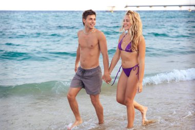  Kafkasyalı çift tatilleri sırasında sahilde yürüyorlar. Tatil, rahatlama ve yaz konsepti