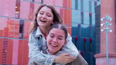 İki arkadaş şehirde keyifli bir anın tadını çıkarıyor, biri diğerine sırtına biniyor. Gülüp kaynaşıyorlar, mutluluk ve dostluk gösteriyorlar. Eğlence ve kaygısız arkadaşlık kavramı.