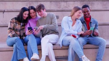 Akıllı telefonlarına bakan bir grup arkadaş kampüste interneti cep telefonuyla tarıyor.