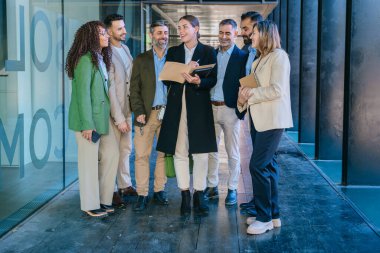 Farklı geçmişlerden bir grup profesyonel dışarıda fikirleri tartışıyor. Ortadaki kadın, konuşmayı özgüvenle yönetiyor. Elinde modern bir şirket ortamında bir defter tutuyor..