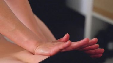 Terapist elleri, bir spa seansı sırasında müşterinin sırtına masaj yapıyor. Yakından bakıldığında rahatlama ve sağlığa odaklı. Vücut bakımı, masaj terapisi ve stres atmak için ideal..