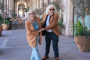  Kafkasyalı yaşlı çift birlikte eğleniyor, güzel bir açık havada dans ediyor ve gülüyor. Yaşam tarzı, aşk, neşe, emeklilik ve ilişki kavramları için mükemmel.. 