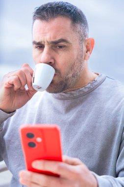 Kafkasyalı heyecanlı bir adam, akıllı telefonuna oynadığı online oyun bahsini kazanıp, açık bir kafede kahve masasında oturup, zafer ve mutluluk anının tadını çıkardıktan sonra sevinçle tepki veriyor. 