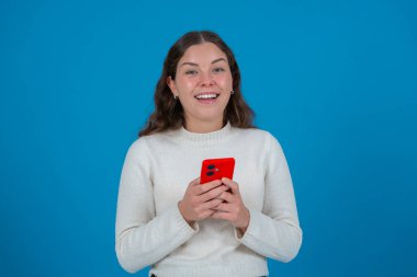 Hayal kırıklığına uğramış bir adam akıllı telefon ekranını şehir ortamında doğrudan kameraya doğrultuyor. Öfkeli ifadesi cihaz, uygulama ya da dijital iletişimde bir sorun olduğunu gösteriyor.. 