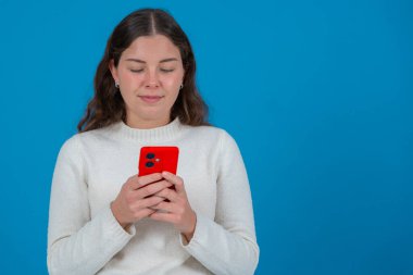 Hayal kırıklığına uğramış bir adam akıllı telefon ekranını şehir ortamında doğrudan kameraya doğrultuyor. Öfkeli ifadesi cihazla, uygulamayla ya da dijital iletişimle ilgili bir sorun olduğunu gösteriyor. Boşluğu kopyala