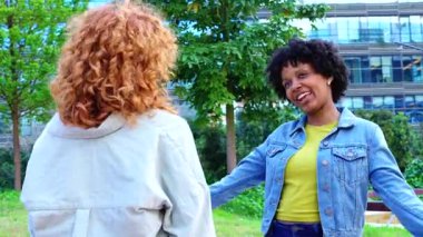  Neşeli Afrika kökenli Amerikalı ve Kafkas dostları, güneşli bir günde yeşil bir şehir parkında buluşup gülüyor ve dostluğu, çeşitliliği, desteği ve pozitif enerjiyi kutluyorlar.