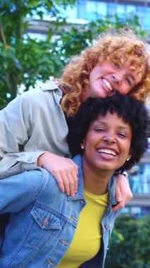 Neşeli genç kadınlar dışarıda eğleniyor, biri diğerini sırtında taşırken hem gülüyorlar, hem de eğleniyorlar, şehir merkezinde birlikte neşeli ve tasasız bir anın tadını çıkarıyorlar. 