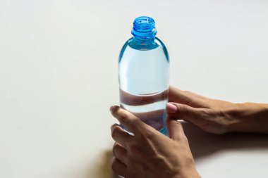 Kız elinde plastik bir şişe su tutuyor. 