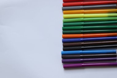 Beyaz arkaplanda farklı renklerde izole işaretler var. Yumuşak uçlu kalemler