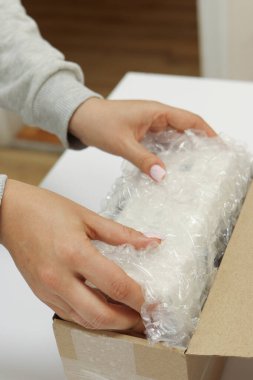 Kadınların elleri koruma paketi için baloncukla paketlenir ve kahverengi karton bir paket kutusuna yerleştirilir. Yüksek kalite fotoğraf