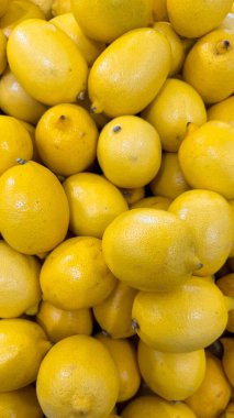  Taze, olgun limonların görüntüsü. Bir sürü sarı limon arka planda. Yakın plan. C vitamini, limon arka planı. Limonlar dükkanda tezgahın üstünde. 