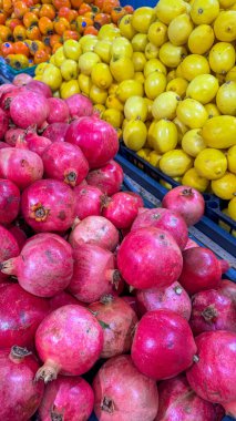  grocery store filled with a variety of fruits . grenades lemons and persimmons. Assortment of fresh fruits at market. grocery shopping concept. High quality photo clipart