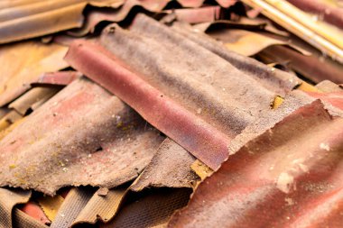 Eski ve çok tehlikeli asbest çatı. Ondulin atığı. Onduline çarşaflar. Bitumen ile kaplanmış, tahta gibi şekillendirilmiş katmanlı karton levhalar. Yüksek kalite fotoğraf