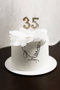 Zarif kadınların beyaz pastası. Süslü ve mumlu. 35. doğum günün kutlu olsun. Geleneksel şenlikli tatlı. Yüksek kalite fotoğraf