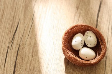 Ahşap bir yüzeyde yumurtaları olan dekoratif yuvalar. Kuş yuvası. Paskalya ve doğa temaları için fotoğraf. Metin, logo veya diğer grafik elementler için solda boş alan. Yüksek kalite fotoğraf